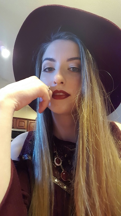 Photo of the website creator, a woman with long brown hair in red clothing.